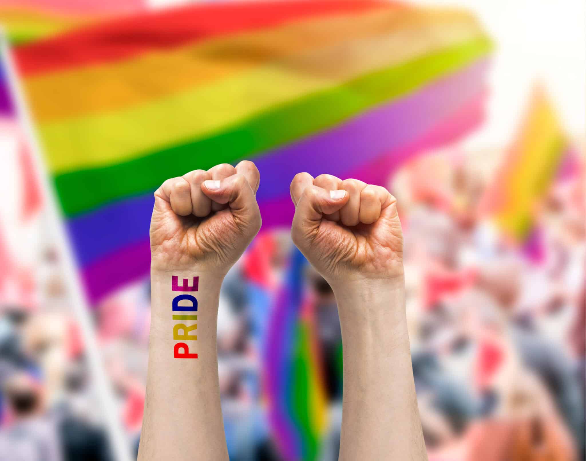 Gay guy's hand with a tattoo that says pride with white background. Symbol of sexual liberation and tolerance